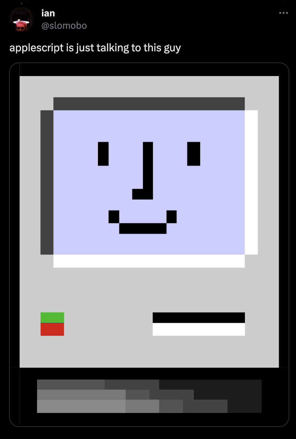 A screenshot of a tweet from slomobo. The tweet says 'AppleScript is just talking to this guy' along with an image of an old Mac icon of a computer with a face.