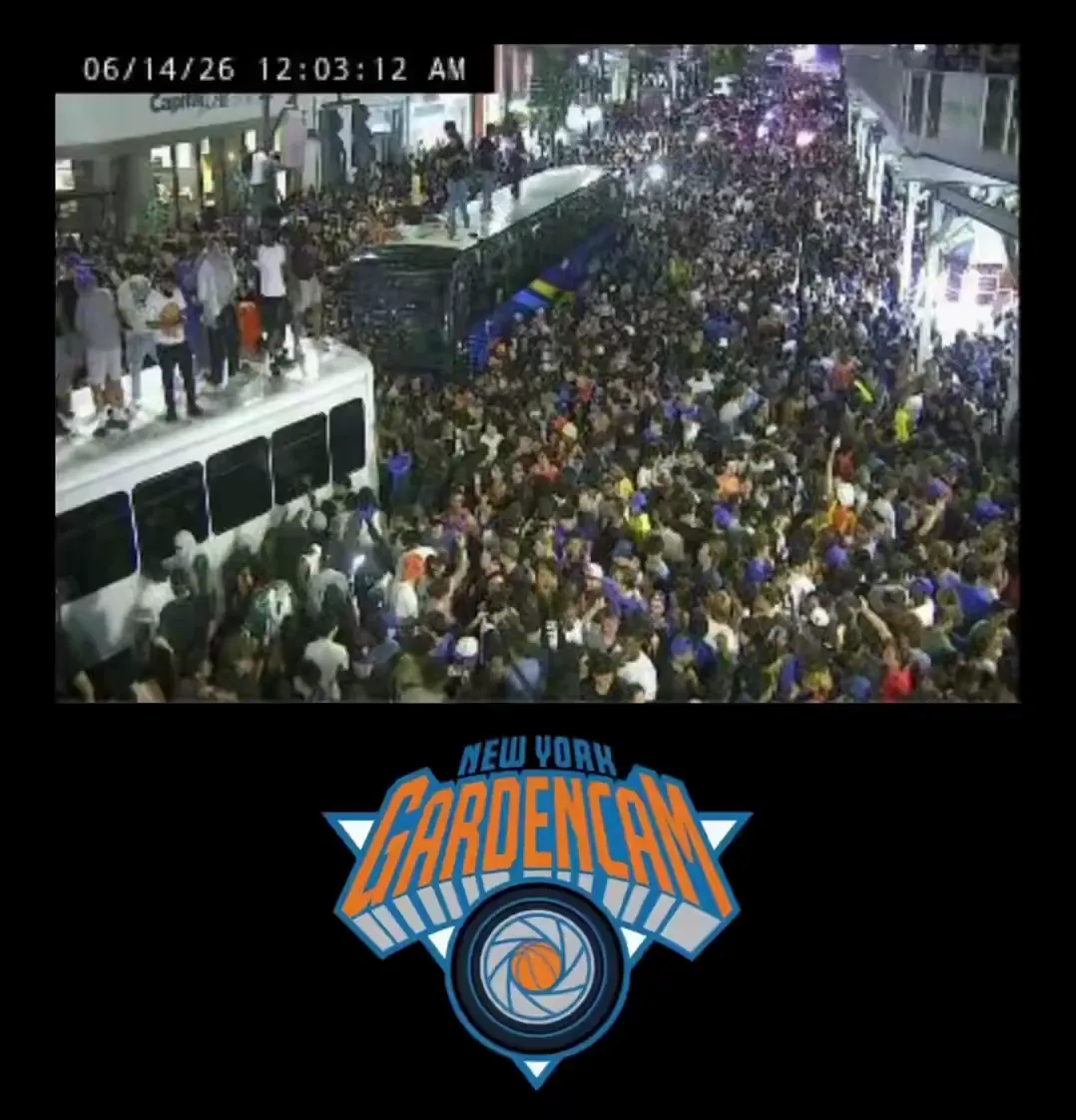 screenshot of gardencam. It shows a massive crowd in a street. Two busses are blocked in traffic. People are standing on the busses.